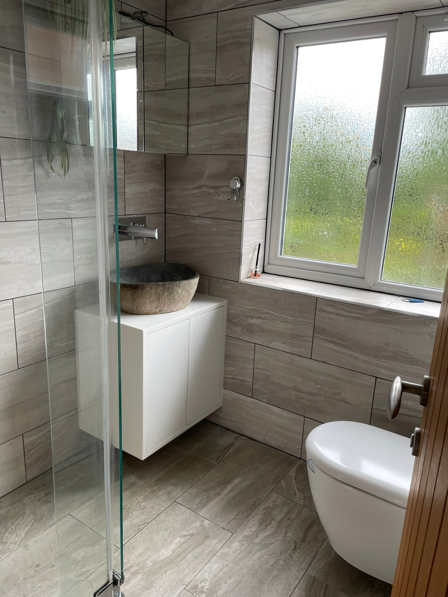 Modern bathroom refurbishment with stone vessel basin, walk-in shower and marble-effect tiling by Ash Villa